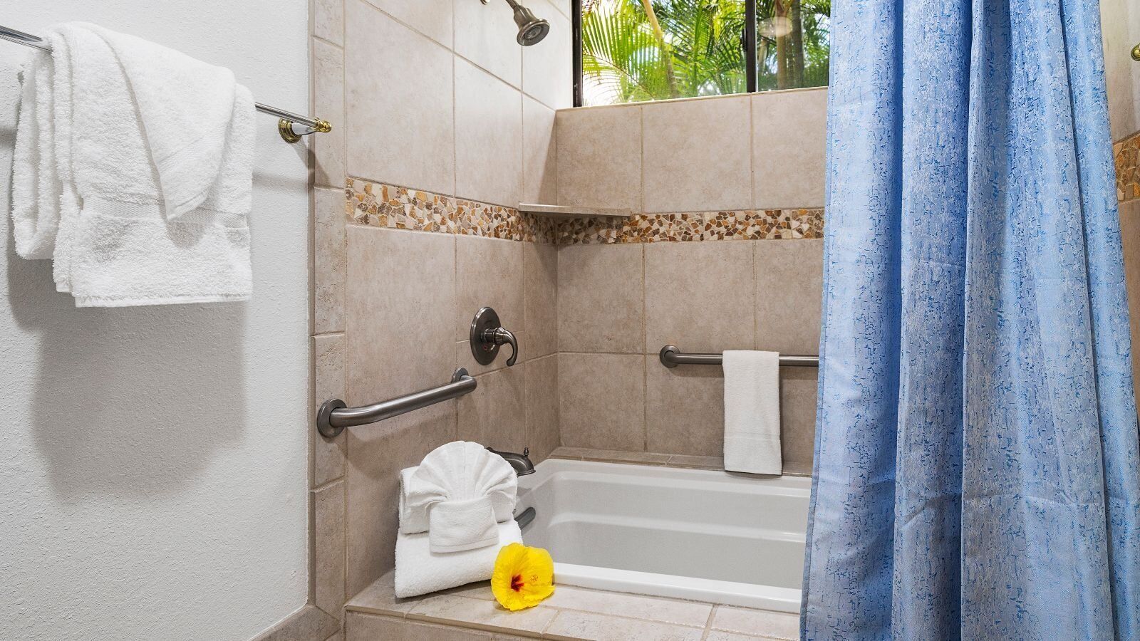 Ein Badezimmer mit einer Badewanne, einer Dusche und einer Haltestange.