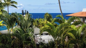 A tropical resort with a pool, palm trees, and a view of the ocean. - Ocean View - No Stairs! - In Unit Washer/dryer -top Floor- Vrkcv (Kailua-Kona)