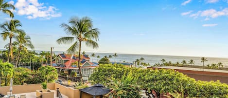 A beachfront property with a patio area, outdoor seating, and a view of the ocean.
