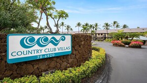 Señal de Country Club Villas con un número de contacto.