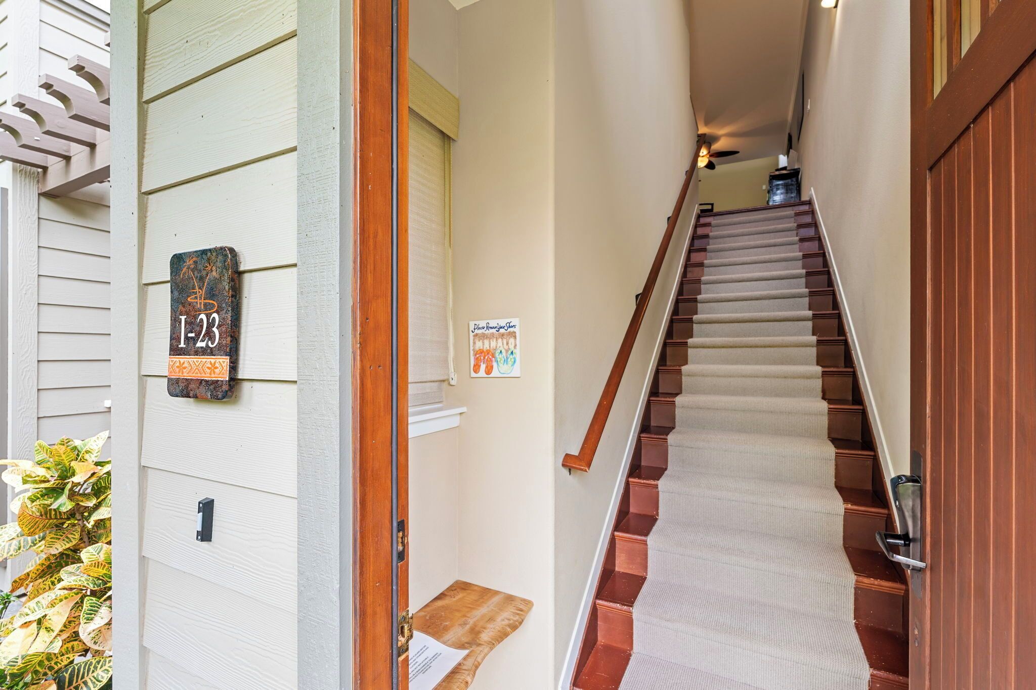 A staircase leading to a second floor with a wooden handrail and a carpeted landing.