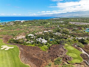 An aerial view of a coastal resort with multiple buildings, a golf course, and a view of the ocean. - Easy Walk to the Beach - Golf Community - Concierge Included - Vrkcv (Kamuela)