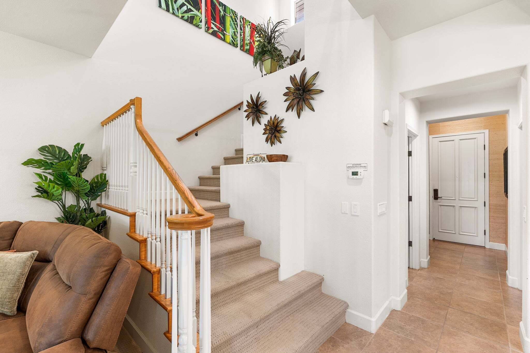 A staircase with wooden railings and beige carpeted steps leading to a landing.