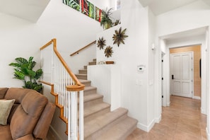 A staircase with wooden railings and beige carpeted steps leading to a landing.