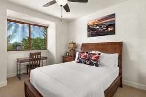 A bedroom with a bed, a desk, a chair, a nightstand, a lamp, and a painting on the wall. - Peaceful Mauna Lani Getaway - Pool, Golf & Private Beach Access - Vrkcv (Kamuela)