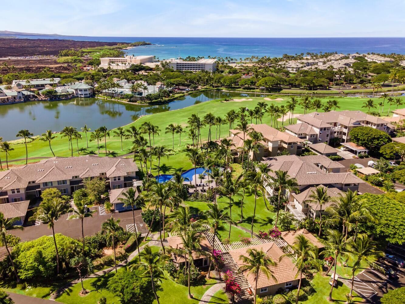 Un resort con diversi edifici, un campo da golf e una distesa d'acqua.