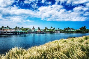 Un hôtel situé au bord de l’eau, composé de plusieurs bâtiments, doté d’un quai et agrémenté de palmiers.