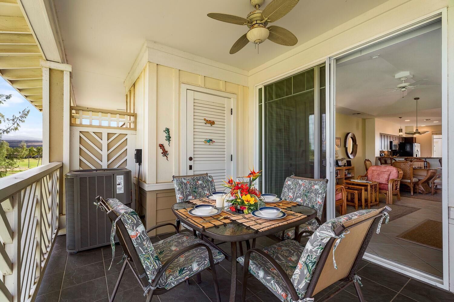 A patio with a table set for four, surrounded by chairs with floral upholstery.