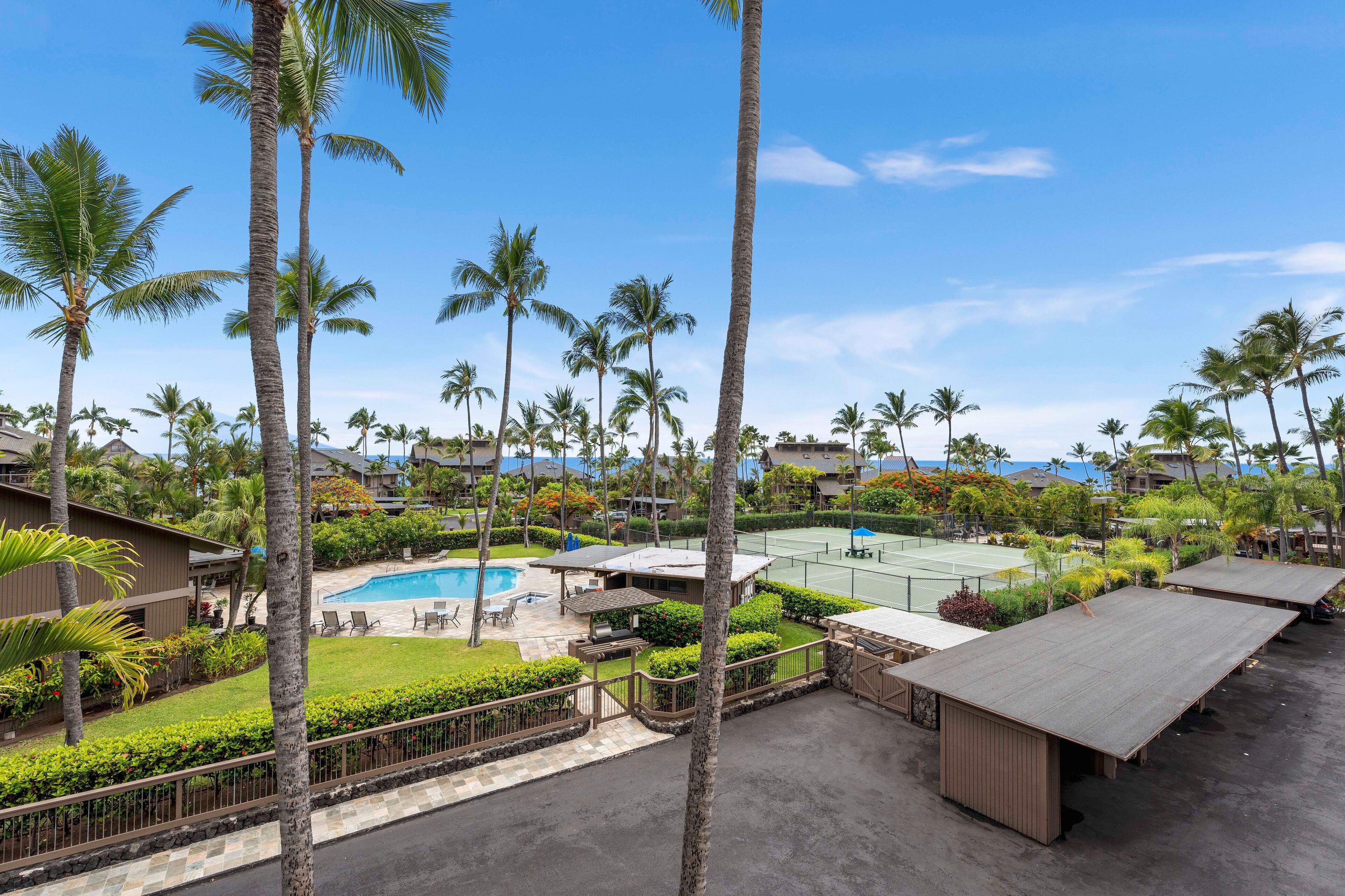 Un resort con piscina, canchas de tenis y palmeras.