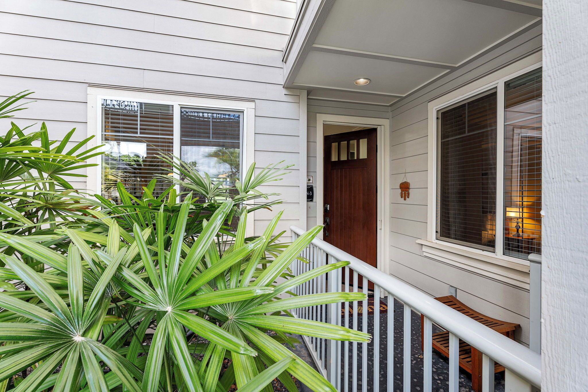 A house with a porch, a wooden door, and a window with blinds.