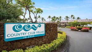 A sign for Country Club Villas with a stone wall and landscaped area. - No Stairs - AC - Fantastic Ocean & Golf Course Views! -vrkcv (Kailua-Kona)