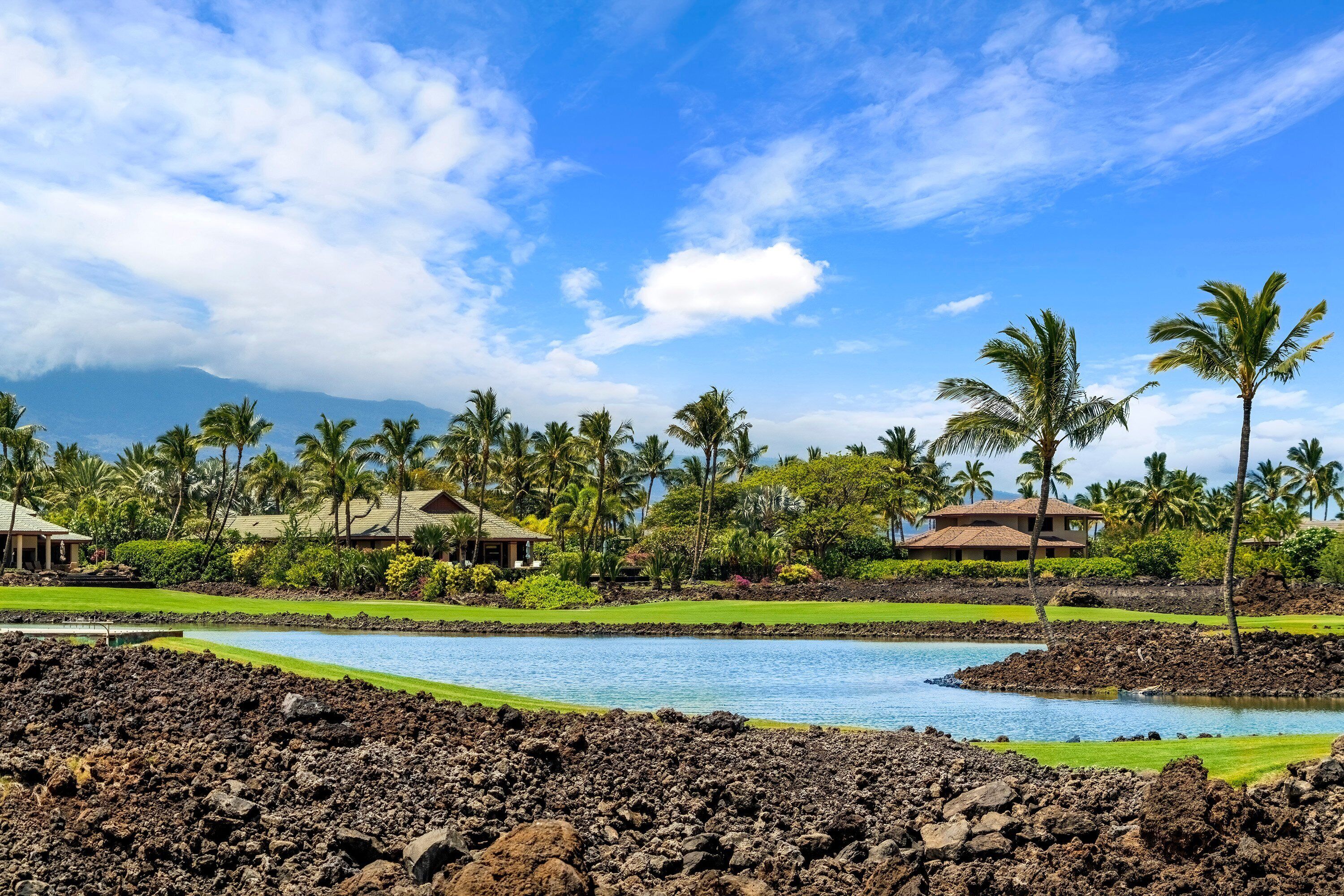 Ein Resort mit Pool, Palmen und Blick auf einen Berg.