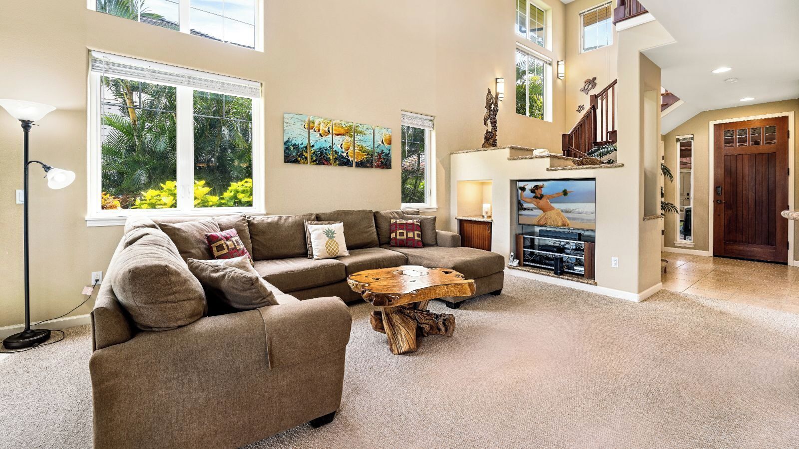 A spacious living room with a sectional sofa, a wooden coffee table, and artwork on the walls.