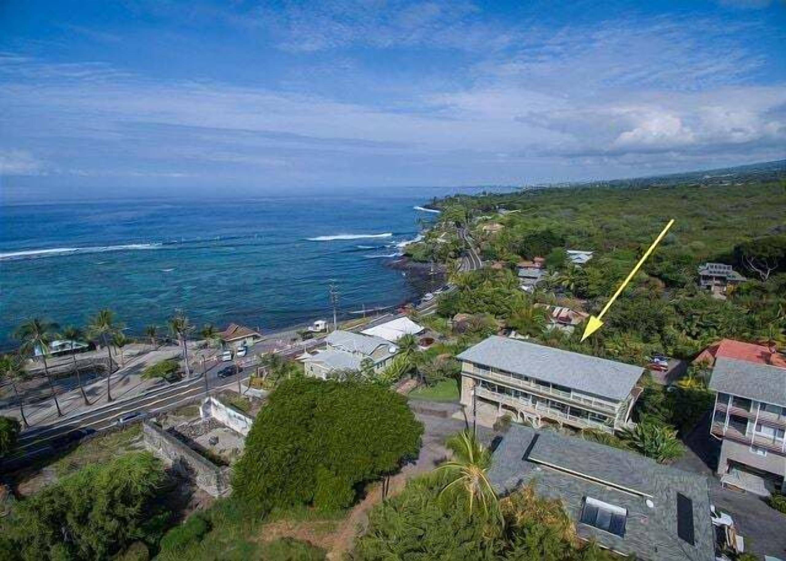 An aerial view of a coastal area with buildings, roads, and a coastline.