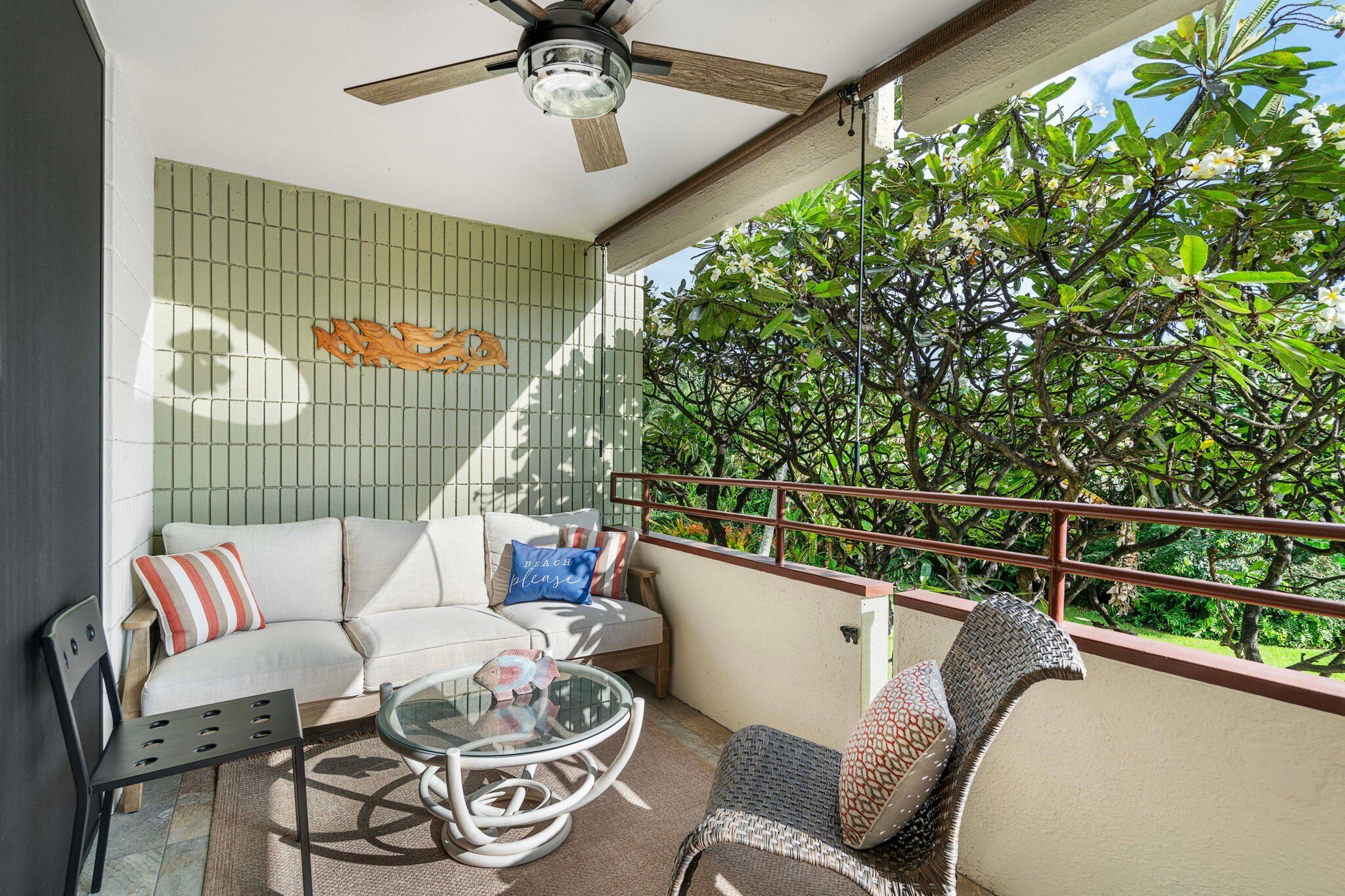 A balcony with a sofa, chairs, and a table.