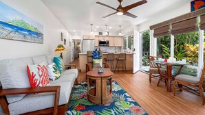 A modern living room with a sofa, a round wooden coffee table, and a dining area with a table and chairs.
