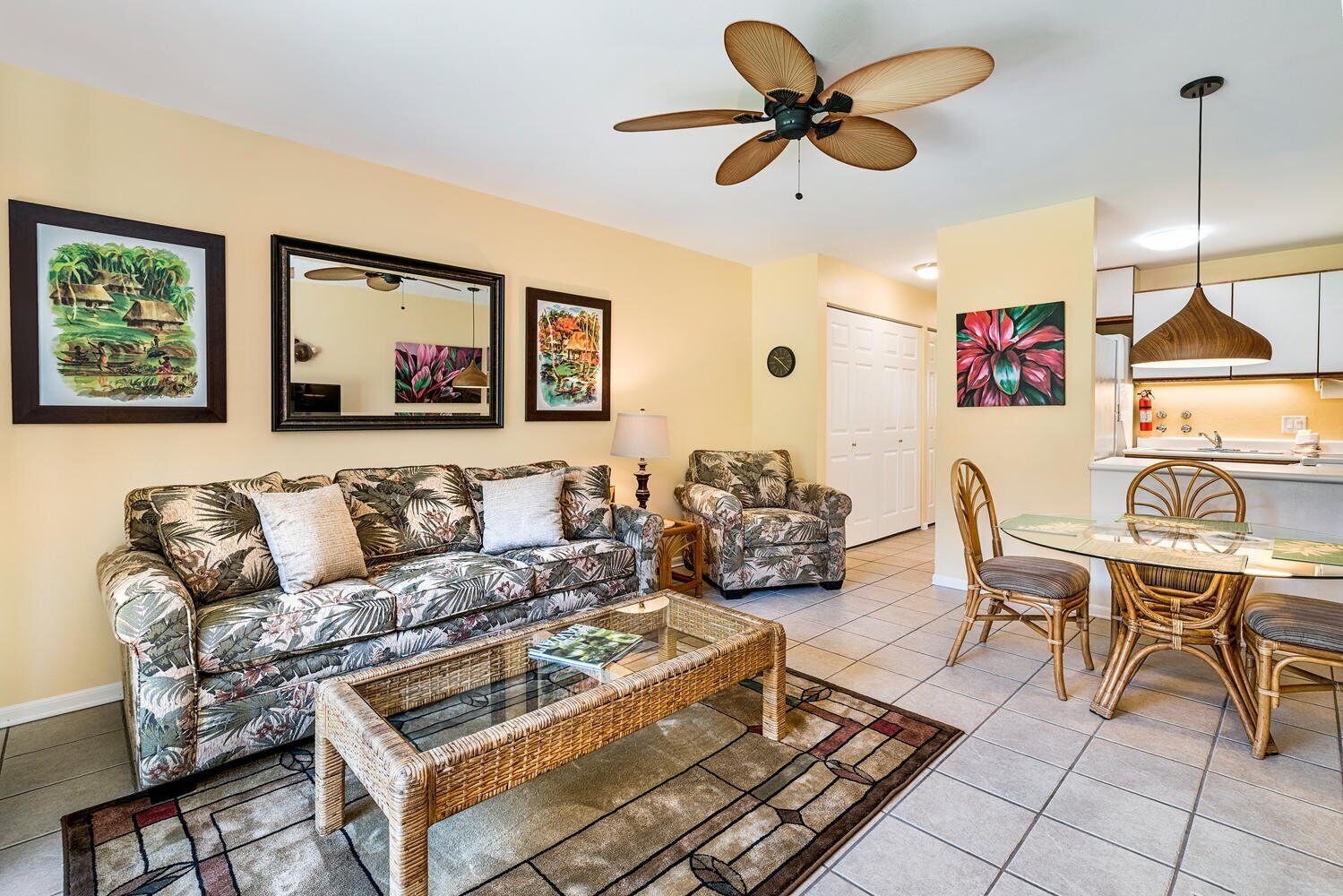 A living room with a sofa, coffee table, and dining area with chairs and a table.