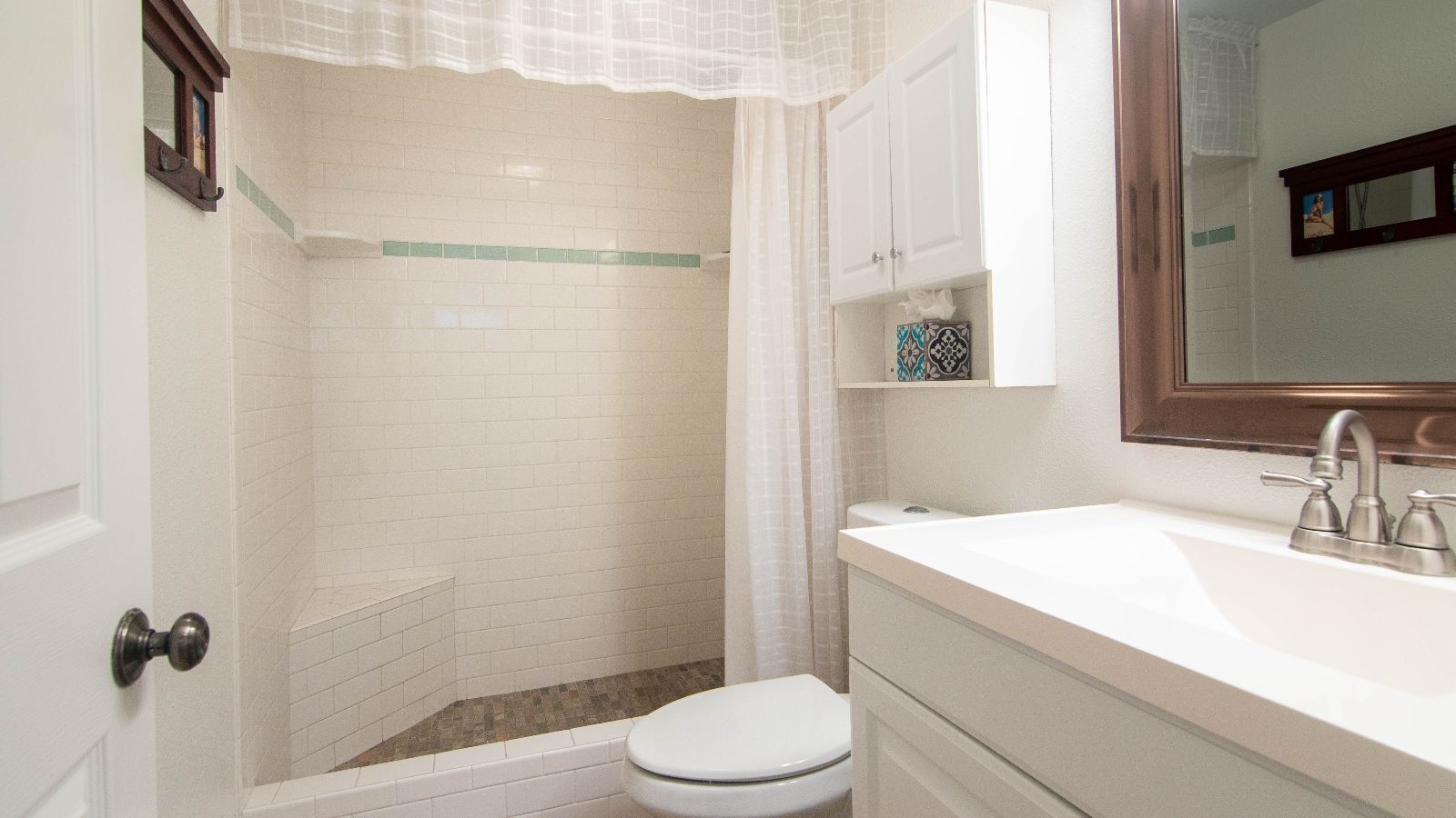 A bathroom with a shower, toilet, and sink.