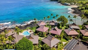 Un resort con varias edificaciones, una piscina y vista al océano.