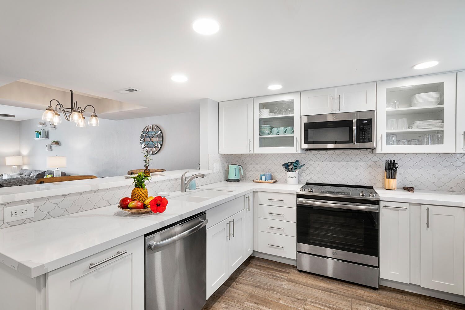 A modern kitchen with white cabinets, stainless steel appliances, a dishwasher, and a microwave.