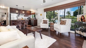 A modern kitchen with dark wood cabinets, stainless steel appliances, and pendant lighting. - Ocean View Unit w Lanai - AC - Near Marketplace! - Vrkcv (Kailua-Kona)