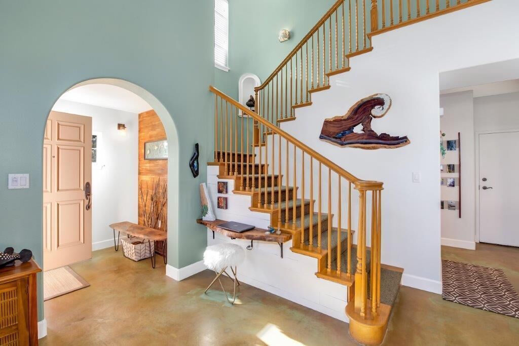 Una escalera con barandillas de madera y un banco al final de la rellano.