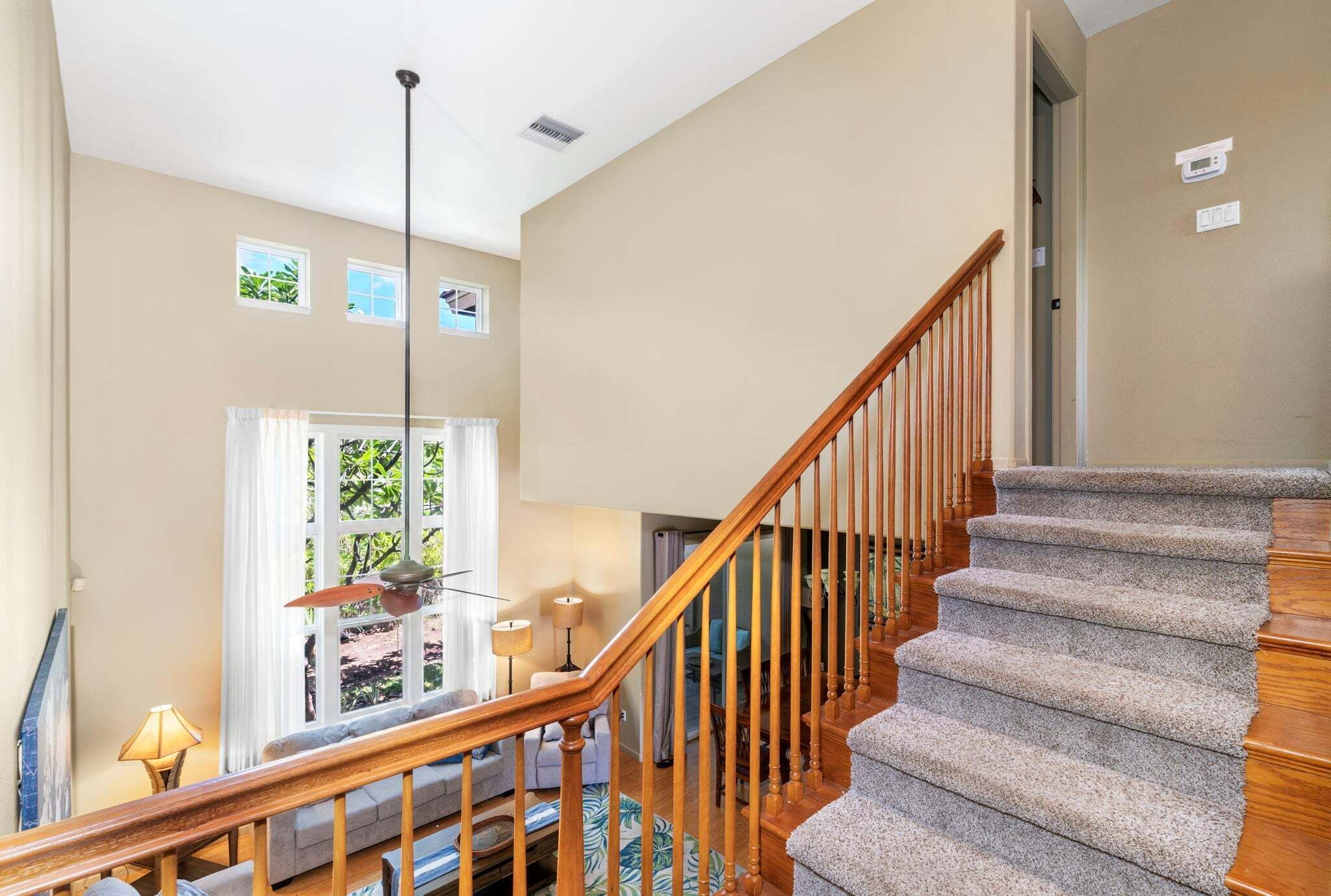 A staircase with wooden railings and carpeted steps leading to a landing.