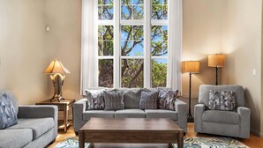 A living room with a sofa, armchair, coffee table, and two floor lamps. - Beautifully Furnished - Hawaiian Villa - AC & Wifi! - Vrkcv (Waikoloa)