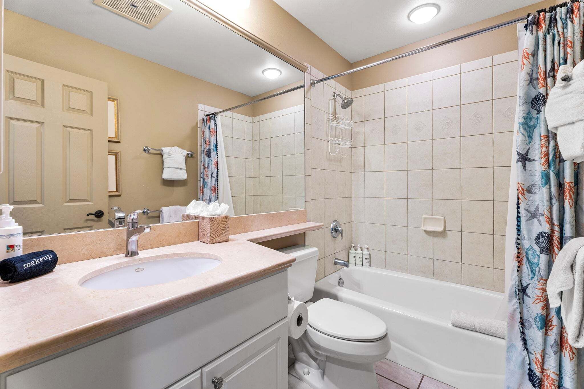 Un baño con lavamanos, inodoro, bañera y cortina de ducha.