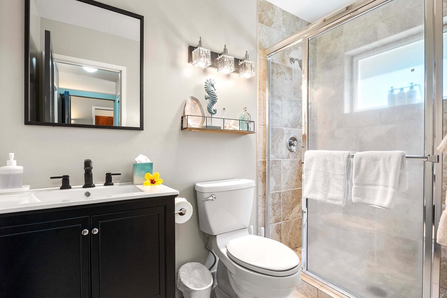 A modern bathroom with a shower, toilet, and sink.