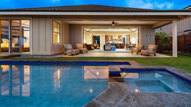 A modern house with a swimming pool, outdoor seating area, and a well-lit interior. - Unbelievable Ocean Front View w Pool - AC - Outdoor Seating!- Vrkcv (Kailua-Kona)