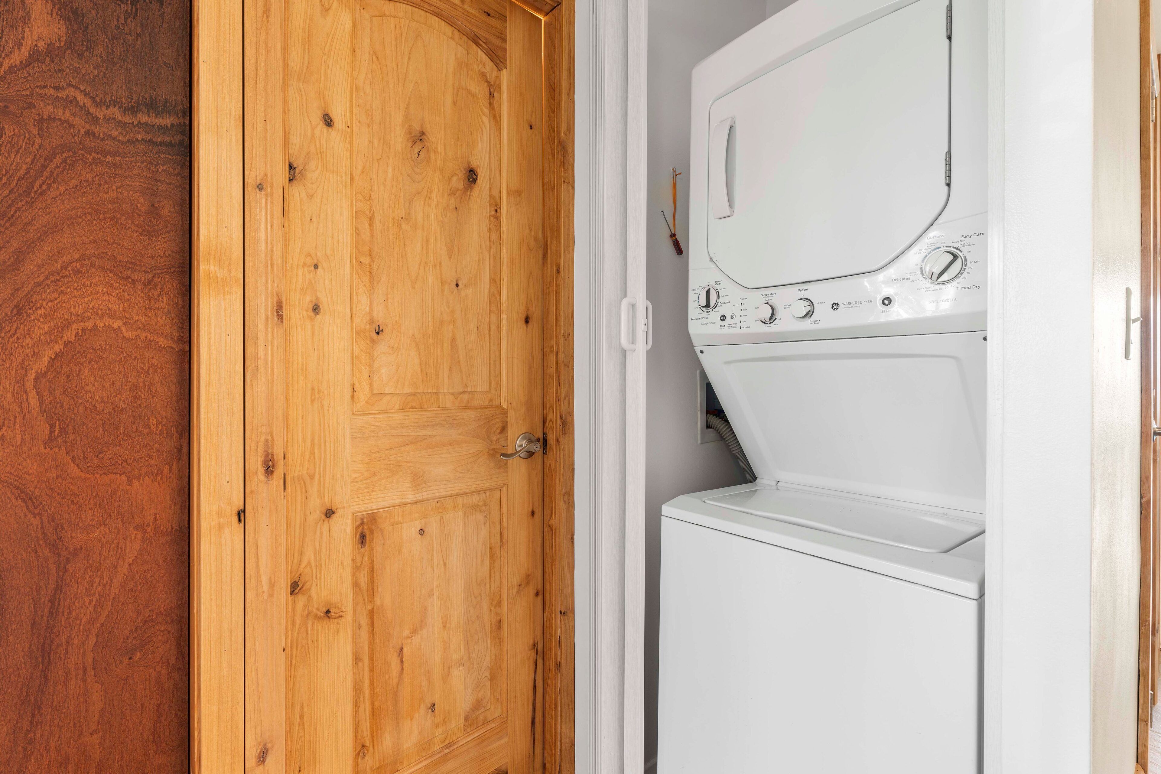 A wooden door with a white laundry machine next to it.
