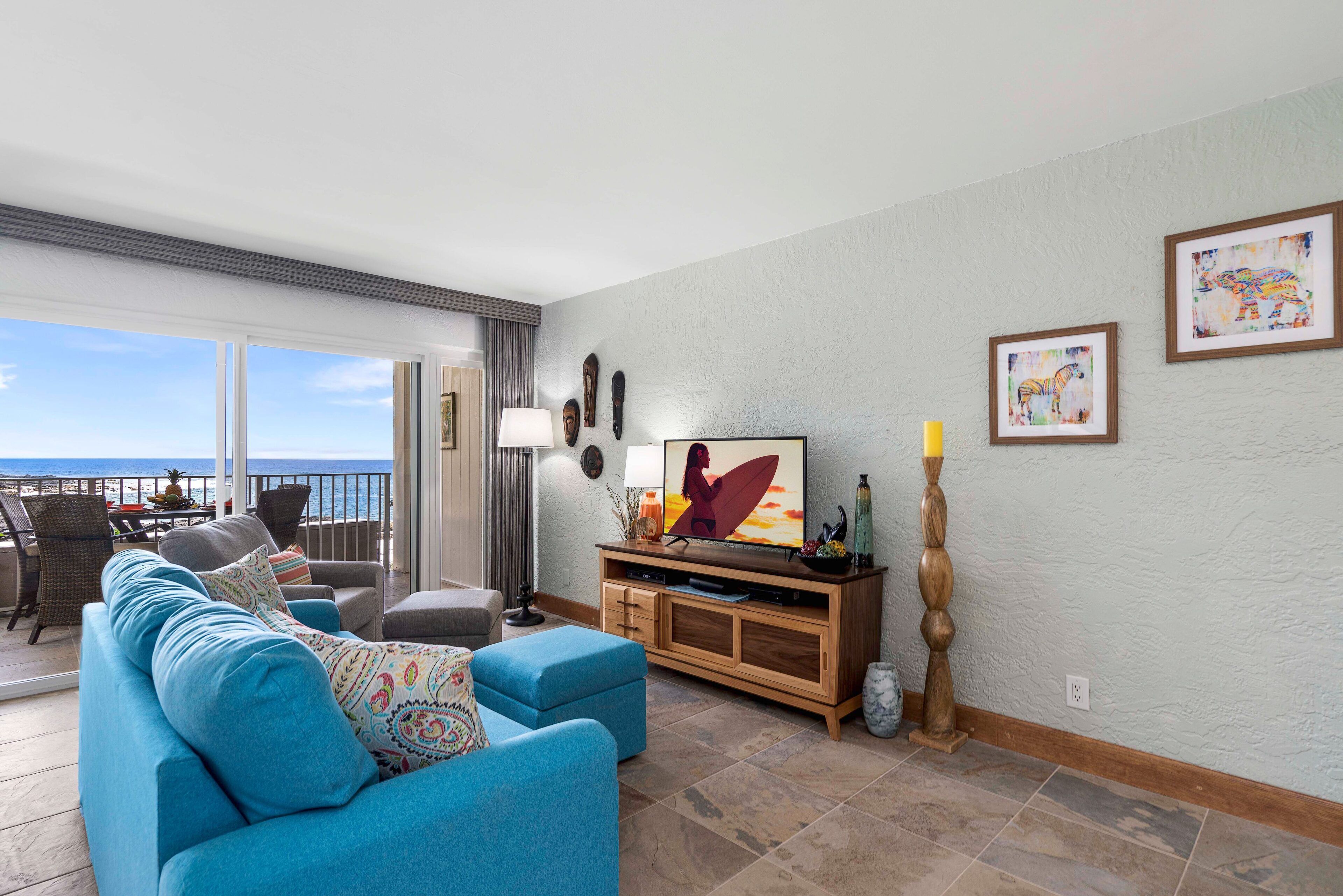 A living room with a sofa, TV, and artwork on the wall.
