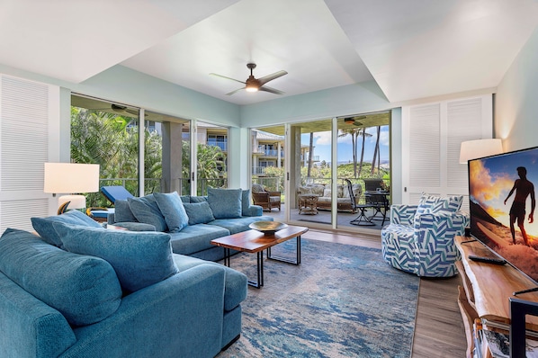 A spacious living room with a large sofa, a coffee table, and a television.