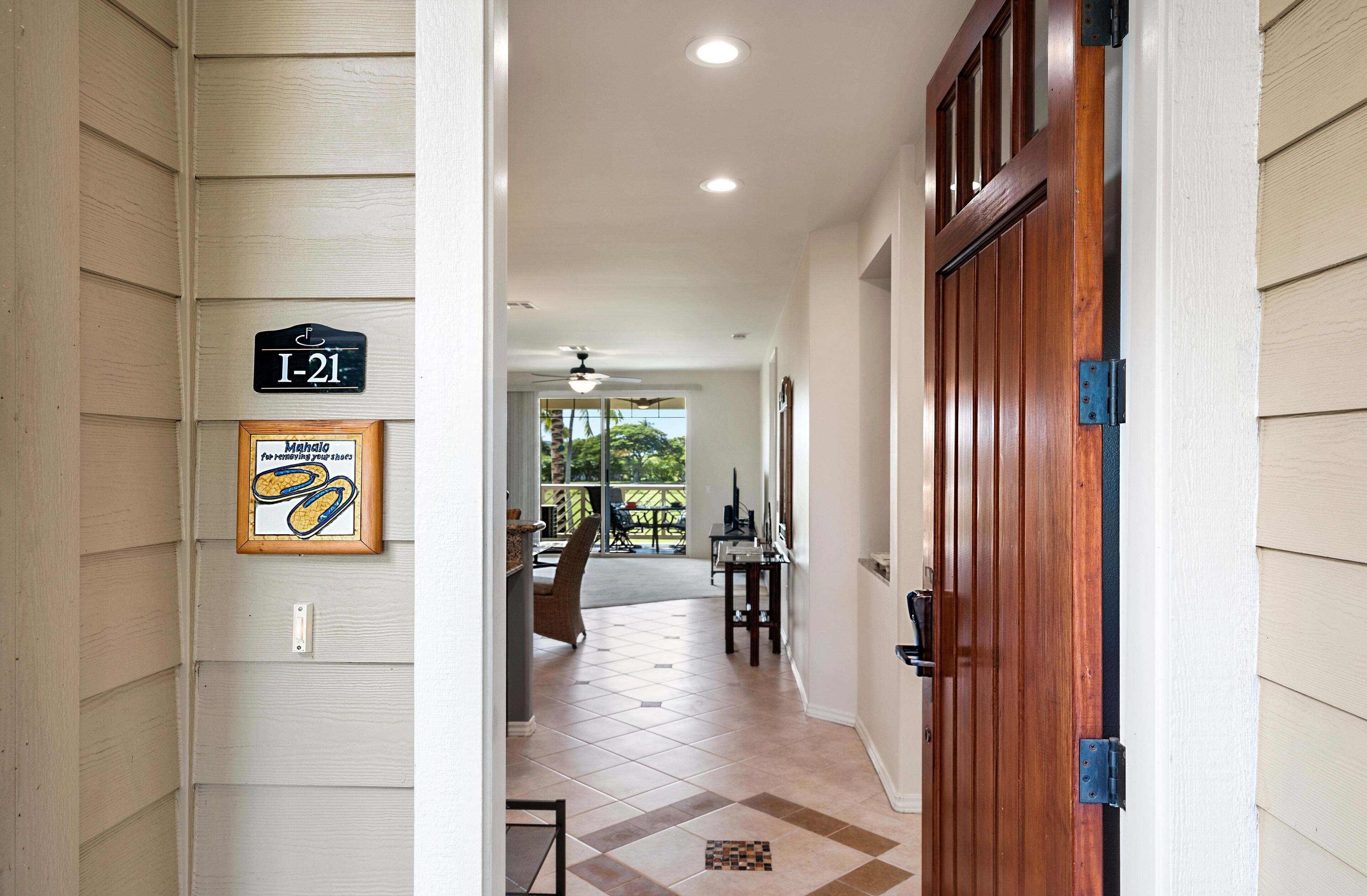A hallway with a wooden door, a sign reading "I-21", and a framed picture of a dog.