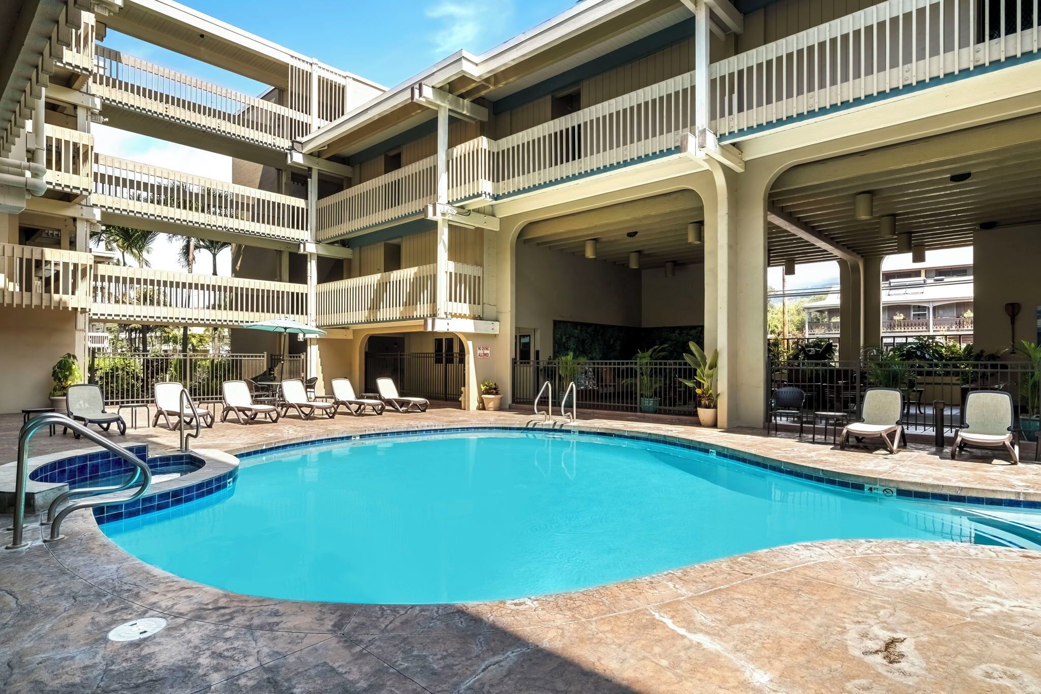 A multi-level pool area with lounge chairs and a clear blue pool.