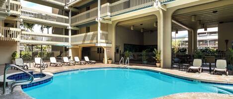 A multi-level pool area with lounge chairs and a clear blue pool.