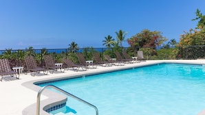 Une piscine avec des chaises longues et vue sur l’océan.
