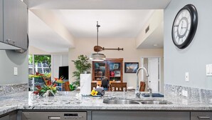 Eine moderne Küche mit Granit-Arbeitsplatten, Edelstahlgeräten und einem Essbereich mit Holztisch und -stühlen.