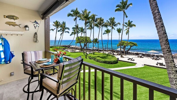 A balcony with a view of the ocean, palm trees, and a neatly arranged outdoor seating area. - Ocean Front! - Second Floor With AC & Lanai! - Vrkcv (Kailua-Kona)