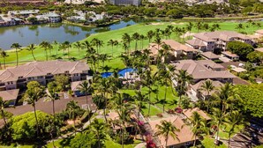 A resort with multiple buildings, a golf course, and a lake.
