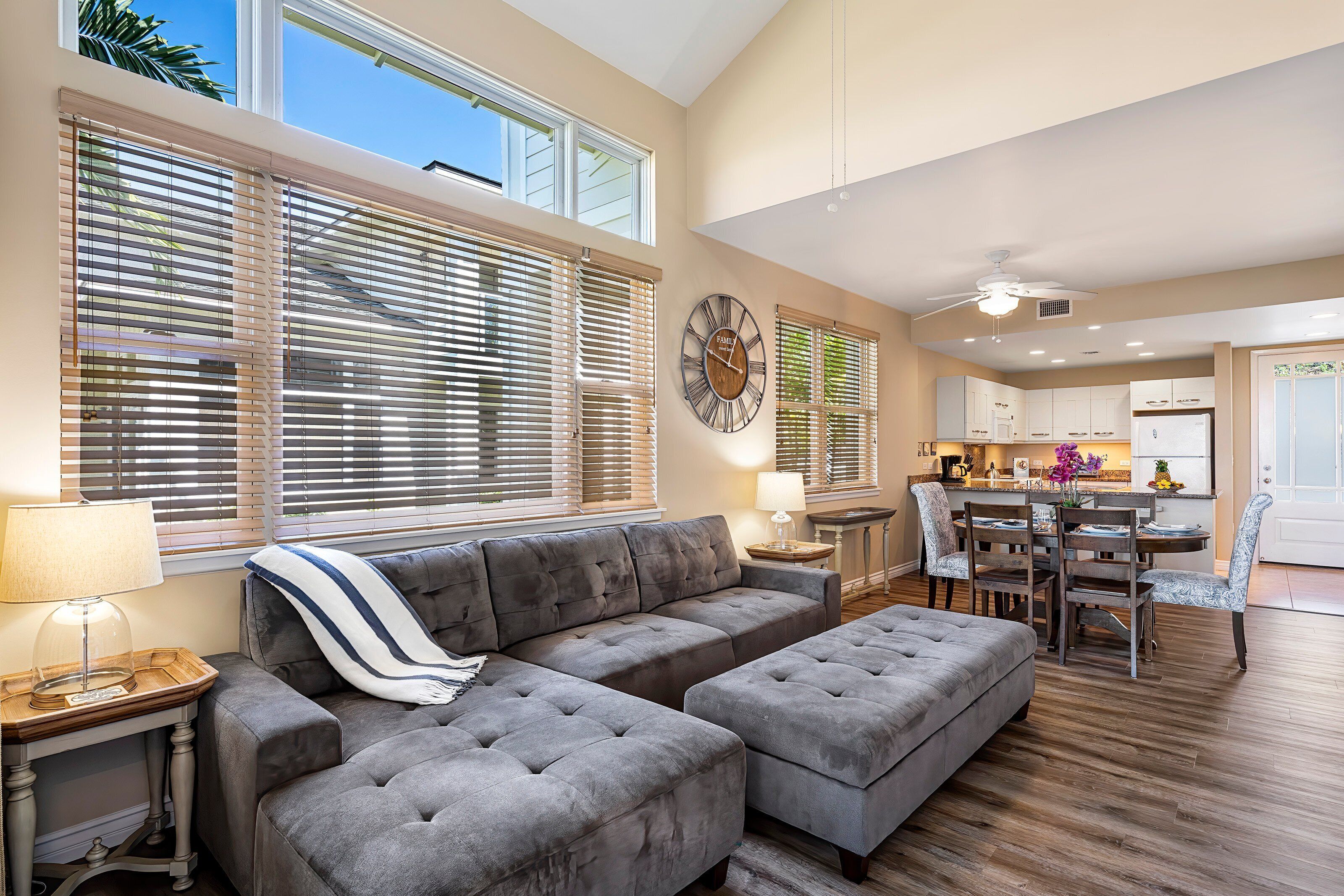 A spacious living room with a sectional sofa, ottoman, and dining area with a table and chairs.
