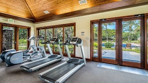 A gym with treadmills, ellipticals, and a stone wall. - Beautiful Townhouse - Great Amenities and Spacious Lanai! Comes With Beach Pass! - Vrkcv (Kamuela)