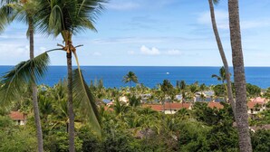 A tropical resort with palm trees, a view of the ocean, and a cluster of buildings. - Ocean & Golf Course Views - 2 Bdrm With Loft - AC - Private Lanai -vrkcv (Kailua-Kona)