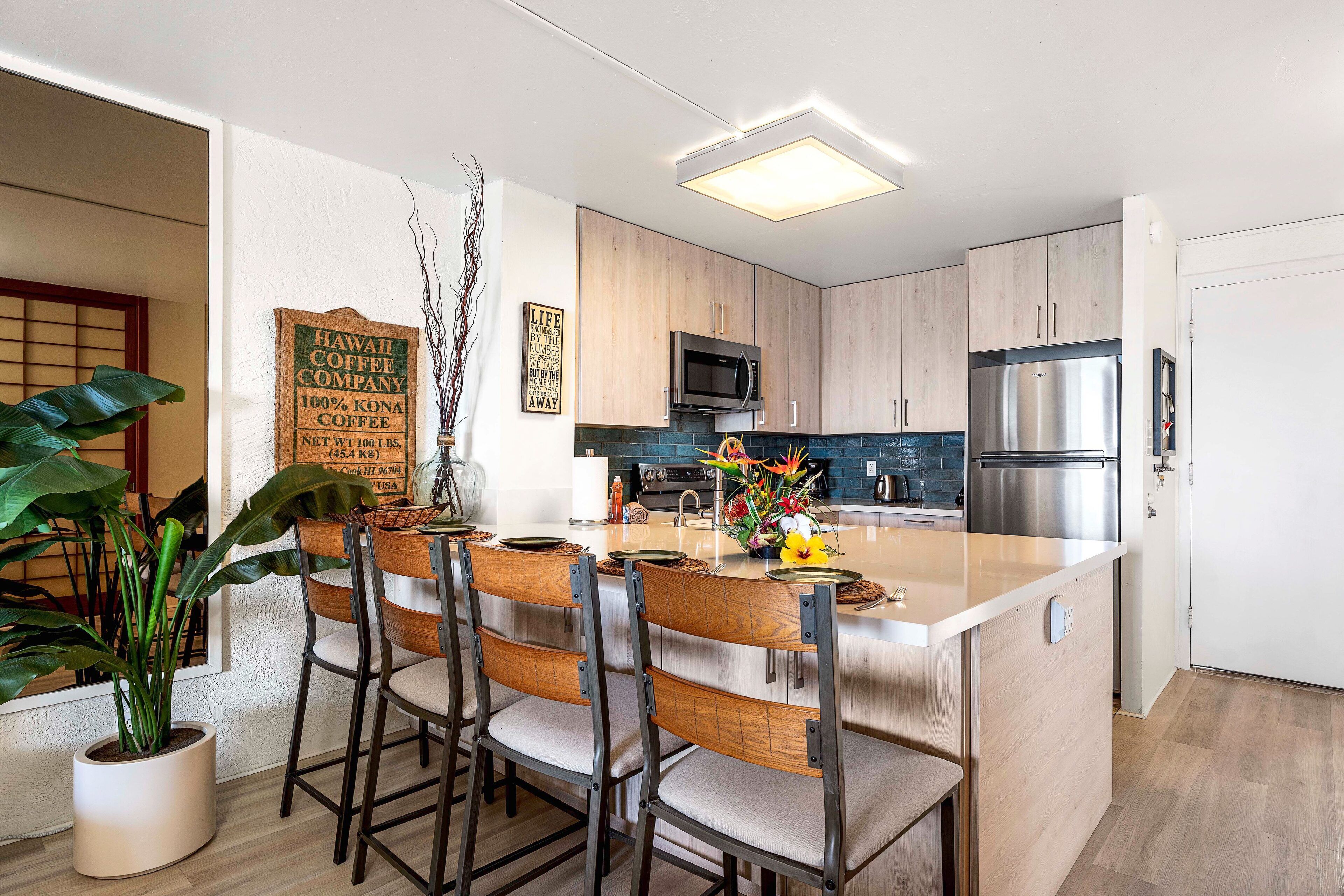 Cozinha moderna com armários de madeira, eletrodomésticos de aço inoxidável e uma ilha central com banquetas.