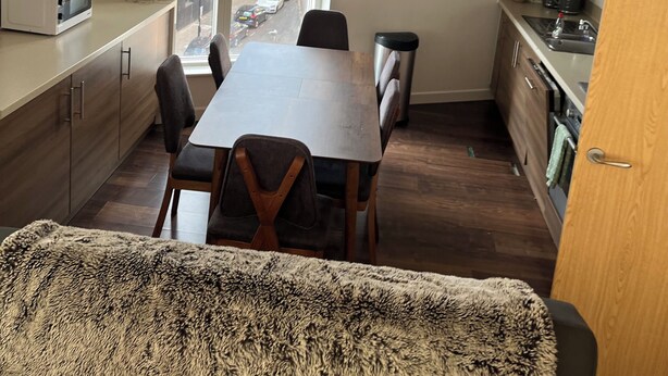 Una cocina moderna con una mesa de comedor, sillas y vistas a la calle.