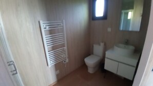Un bany amb vàter, rentapel i barra de tovalloles.