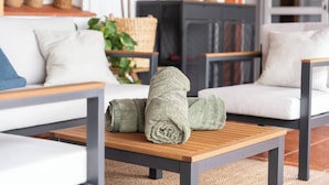 Un salon moderne avec une table basse en bois, deux canapés blancs et une cheminée.