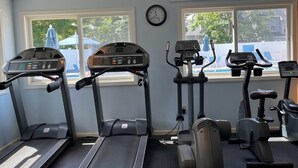 Ein Fitnessstudio mit Laufbändern, Crosstrainern und Ergometer.
