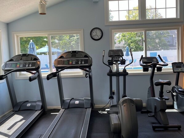 A gym with treadmills, elliptical machines, and stationary bikes.